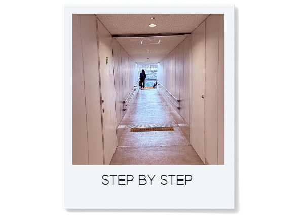 国立競技場の長い通路の先に出口の光が見えるポラロイド風写真「STEP BY STEP」